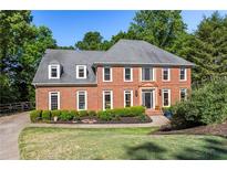 Stately brick home with manicured lawn, mature trees, and tasteful landscaping at 710 Leeds Garden Ter, Alpharetta, GA 30022