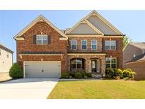 Beautiful brick two-story home with a well-manicured lawn and attached two car garage at 4041 Woodward Walk Ln, Suwanee, GA 30024