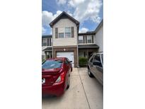 Two story townhome with a one car garage, neutral siding, and dark shutters at 1258 Chinon Pt, Lithonia, GA 30058