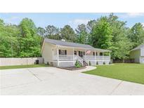 Charming home with covered porch, landscaped front, and driveway at 37 Winesap Ct, Temple, GA 30179