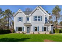 Charming two-story home features blue shutters, a well-manicured lawn, and a welcoming entrance at 1462 Stephens View Dr, Loganville, GA 30052