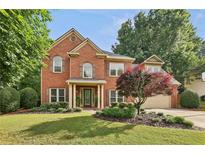 Charming two-story brick home with a well-manicured lawn and mature landscaping at 6720 Wolford Ct, Johns Creek, GA 30097