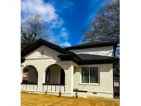 Charming white brick home with black trim and a beautifully arched entryway at 1740 Langston Sw Ave, Atlanta, GA 30310