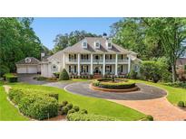 Elegant two-story home with a circular driveway and fountain, showcasing its classic architectural details at 5045 Harrington Rd, Johns Creek, GA 30022