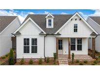 Charming exterior showcasing white siding, dormer window, and brick entryway at 515 Godfrey Dr, Cumming, GA 30040