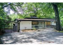 Charming single story home featuring gated entrance, modern design elements, and a beautifully landscaped front yard at 1676 Moores Mill Nw Rd, Atlanta, GA 30327