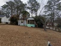 Charming home featuring a screened porch, surrounded by mature trees and an expansive front yard at 2010 Mcafee Pl, Decatur, GA 30032