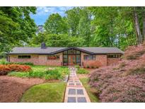 Charming brick home featuring a well-manicured lawn, garden, and a welcoming stone walkway at 3270 Leslie Ne Ct, Atlanta, GA 30345
