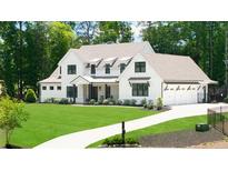 Charming two-story home with a well manicured lawn and an attached three car garage at 604 Trinity Church Rd, Canton, GA 30115