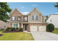 Charming two-story home features a brick facade, two-car garage, and well-maintained lawn at 1340 Delo Ln, Cumming, GA 30041