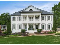 Elegant white brick home featuring a symmetrical design, columns, and lush landscaping at 139 Grandmar Chase, Canton, GA 30115