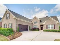 Charming brick home featuring manicured landscaping, a two-car garage, and a welcoming front entrance at 4217 Brentwood Dr, Buford, GA 30518