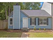 Charming blue home with a well-maintained front yard, black shutters and chimney at 6597 Ivy Log Dr, Austell, GA 30168