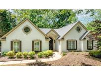 Charming white brick home featuring a well-manicured lawn and mature trees at 3335 Ashton Dr, Suwanee, GA 30024