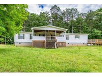 Charming single-story home features a large front porch, wooden deck, and a spacious lawn with mature trees at 743 New Hope Rd, Lawrenceville, GA 30046