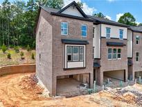 Modern brick townhome with attached garage and stylish architectural details under a bright sky at 2 Rock Park Way # 13, Tucker, GA 30084