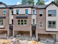 Newly constructed brick townhomes featuring open garage space and large window views at 4 Rock Park Way # 14, Tucker, GA 30084
