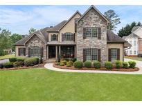 Charming stone and tan two-story home with manicured lawn and mature landscaping at 6263 Fernstone Nw Trl, Acworth, GA 30101