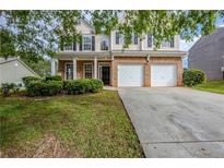 Charming two-story home with a brick facade, attached two-car garage, and well-maintained front yard at 8826 Lakecrest Way, Union City, GA 30291