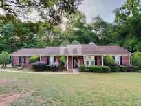 Charming brick home with a well-maintained front yard and mature trees providing shade at 119 Michelle Dr, Mcdonough, GA 30252
