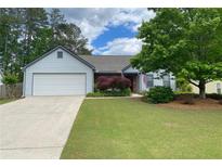 Charming single-story home with well-maintained lawn, attached garage, and inviting curb appeal at 5298 Autumn Run Dr, Powder Springs, GA 30127