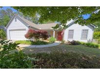 Charming single-story home with well-maintained landscaping and a red front door at 5298 Autumn Run Dr, Powder Springs, GA 30127