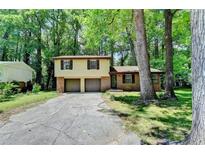 Charming two-story home with brick and siding, a two-car garage, and surrounded by mature trees at 6419 Danbury Ln, Norcross, GA 30093