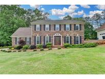 Charming two-story brick home with a manicured lawn and mature landscaping creates a welcoming curb appeal at 478 Guilford Cir, Marietta, GA 30068