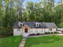 Charming ranch-style home with a well-manicured lawn and a classic brick exterior with a wooded backdrop at 1125 Murray Sw Cir, Marietta, GA 30064