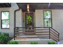 Charming front porch featuring a gray brick exterior, modern railings and well-manicured landscaping at 1350 May Avenue # 14, Atlanta, GA 30316
