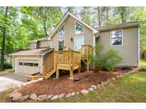 Charming two-story home with a wooden deck, light blue front door, and well-maintained landscaping at 2445 Deerfield Nw Dr, Kennesaw, GA 30144