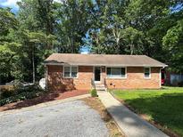 Charming single-story brick home with a well-maintained front yard and walkway leading to the entrance at 2059 Clearwater Se Dr, Marietta, GA 30067