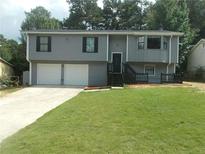 Charming gray two-story home featuring a well-manicured lawn and a two-car garage at 2845 Woodhollow Ln, Jonesboro, GA 30236