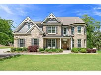 Charming two-story brick home with manicured landscaping and a welcoming front porch at 592 Hayes Rd, Auburn, GA 30011