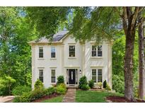 Charming two-story home with manicured lawn and lush, mature trees enhancing curb appeal at 1667 Willow Way, Woodstock, GA 30188