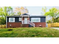 Charming, renovated single-Gathering home with brick foundation, black siding, and bright white trim at 947 Rebel Forest Dr, Atlanta, GA 30315
