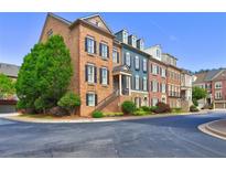 Charming brick townhomes featuring individual entryways and manicured landscaping creating a welcoming curb appeal at 4206 Whitby Se Way # 15, Smyrna, GA 30080