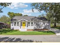 Charming single-story home with yellow front door and well-manicured lawn at 7540 Conyers St, Lithonia, GA 30058