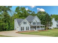 Charming two-story home featuring a welcoming front porch and lush landscaping at 102 Woodsfield Ln, Hiram, GA 30141