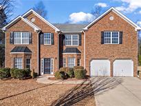 Charming two-story brick home featuring an attached two-car garage and well-maintained landscaping at 221 Cutbank Sw Ct, Atlanta, GA 30331
