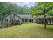 Charming single-story home with stone accents, mature landscaping, and a spacious front yard at 3601 Club Nw Dr, Kennesaw, GA 30144