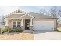 Charming one-story home with a stone facade, covered porch, and well-manicured front yard and a two car garage at 422 Murphy Avenue, Canton, GA 30114