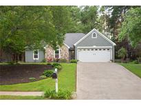 Charming home featuring a combination of stone and siding, complemented by a two-car garage and a well-maintained front yard at 1605 Barrier Rd, Marietta, GA 30066