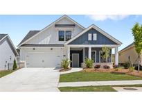 Charming two-story home featuring white and navy blue siding, a two-car garage, and a well-manicured lawn at 313 Sassafras Way, Holly Springs, GA 30115