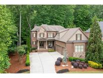 Beautiful two-story home with a brick and stone facade, lush landscaping, and a spacious driveway at 2239 Tayside Nw Xing, Kennesaw, GA 30152
