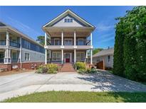 Charming two-story home boasts double balconies, landscaped front yard and a spacious driveway at 3416 Harrison Rd, Atlanta, GA 30344