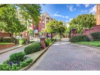 Gated entrance to building with brick columns and mature landscaping creating an inviting arrival at 211 Colonial Homes Nw Dr # 2203, Atlanta, GA 30309