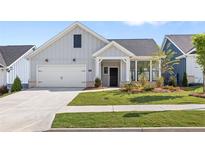 Charming single-Gathering home featuring a well-manicured lawn, a two-car garage, and a welcoming front porch at 309 Sassafras Way, Holly Springs, GA 30115