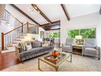 Inviting living room featuring vaulted ceilings, exposed beams, and an adjacent dining area, enhancing the open layout at 2075 Six Branches, Roswell, GA 30076