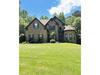 Charming brick home featuring a manicured lawn and lush landscaping at 3400 Suwanee Creek Rd, Suwanee, GA 30024